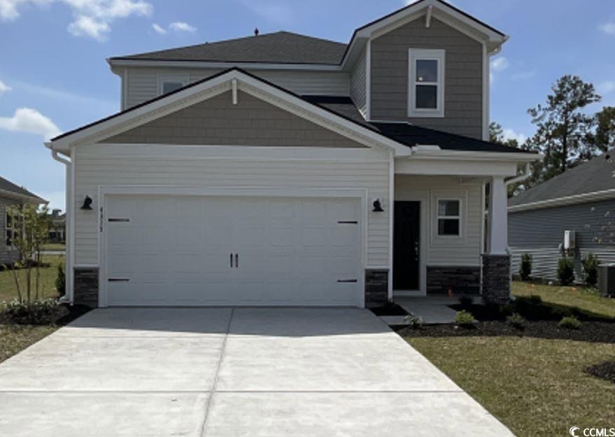 Craftsman inspired home featuring a garage, drivew