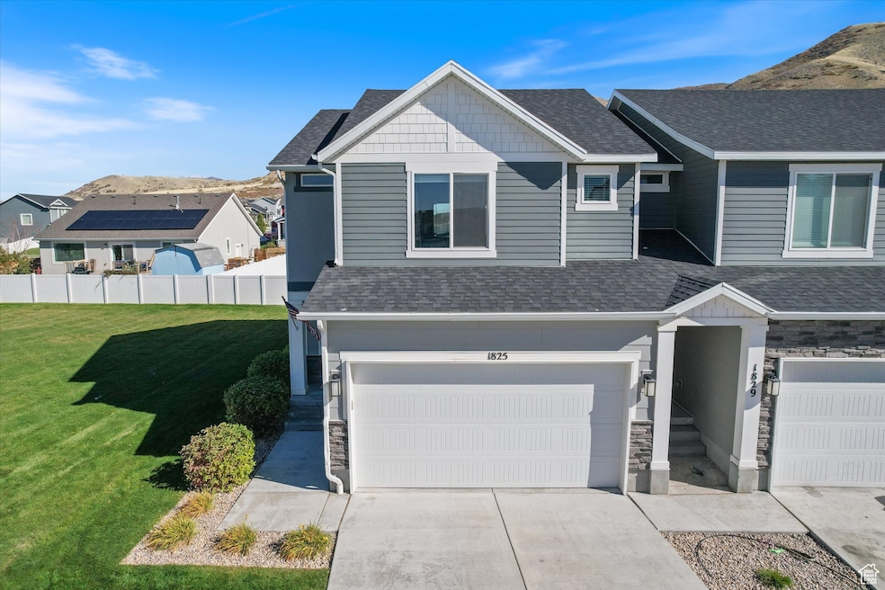 View of front of house featuring a mountain view, stone siding, roof with shingles, driveway, and an attached garage