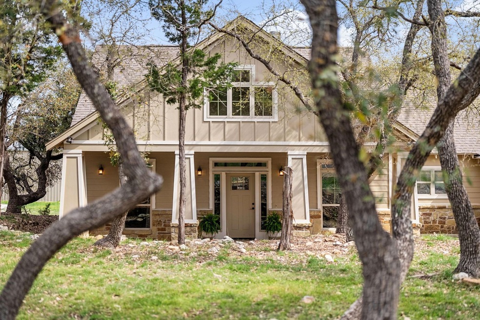 The front facade of this Craftsman-style home is a picture-perfect blend of rustic charm and timeless elegance, nestled amidst the tranquil beauty of the surrounding woods. 