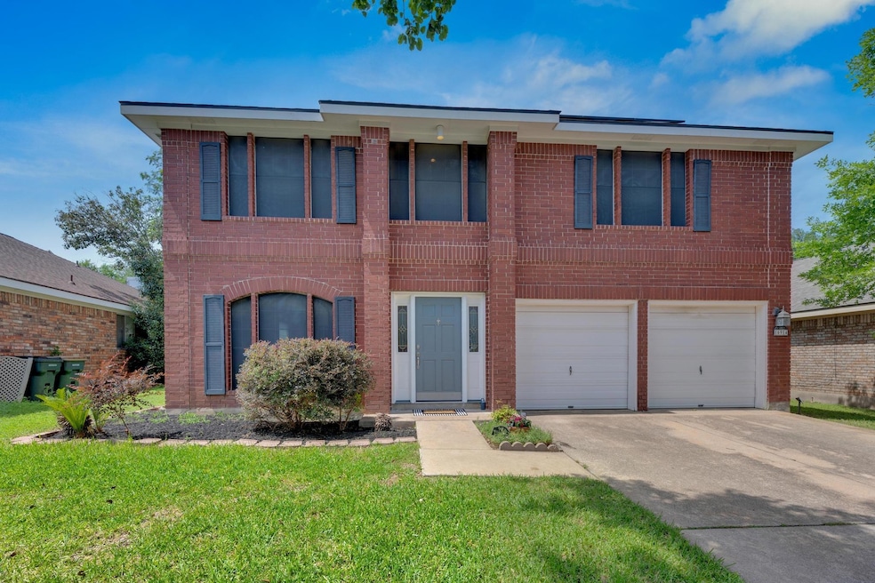 View of front of property featuring a garage, dri
