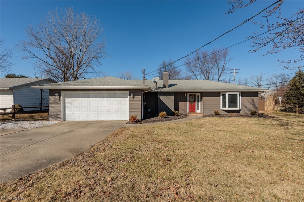 Single story home featuring a garage and a front yard