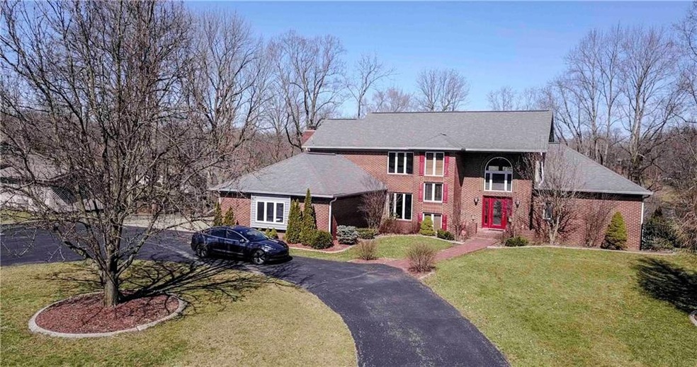 Aerial view shows horseshoe driveway in front of the residence. 