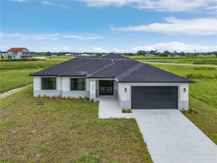Single story home featuring a garage and a front y