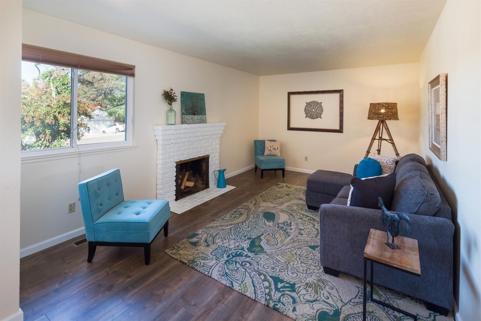 Front living room features new flooring and a fire