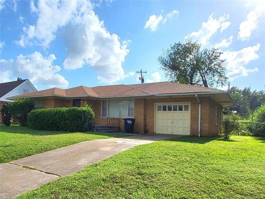 Single story home featuring a front lawn and a gar