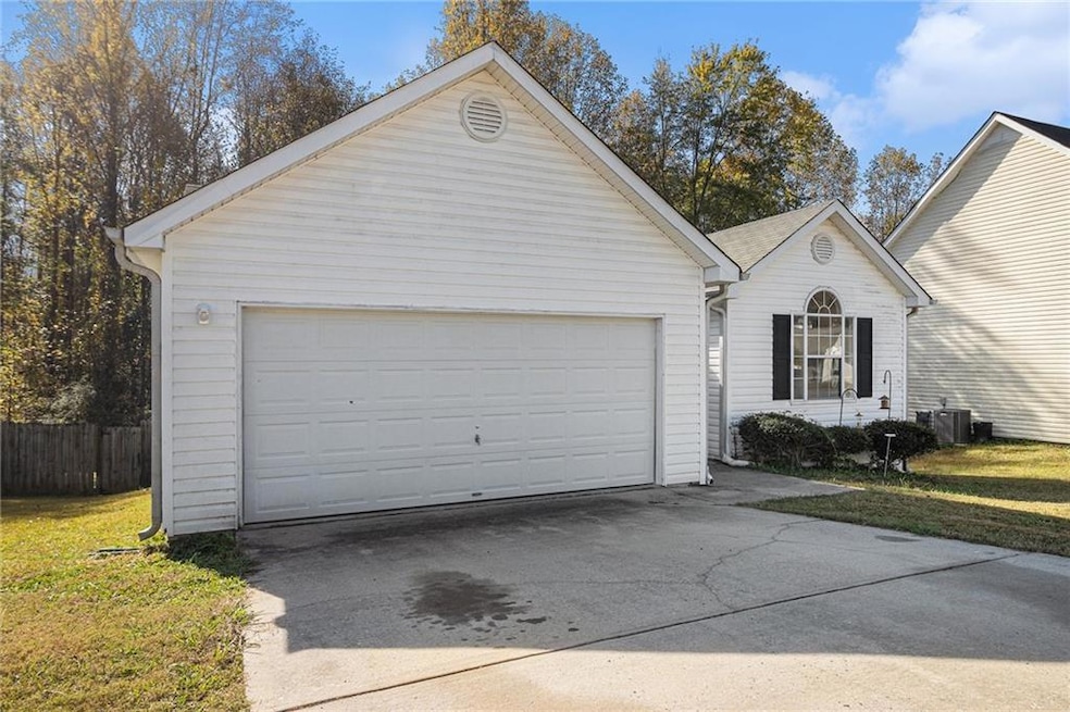 View of front facade featuring a garage and concrete driveway