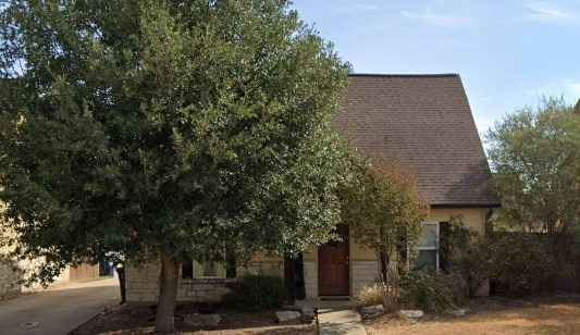 Obstructed view of property with a shingled roof
