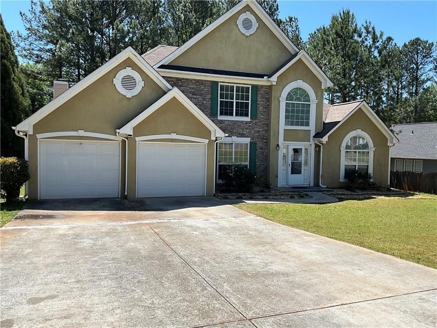 View of front property featuring a front lawn and a garage