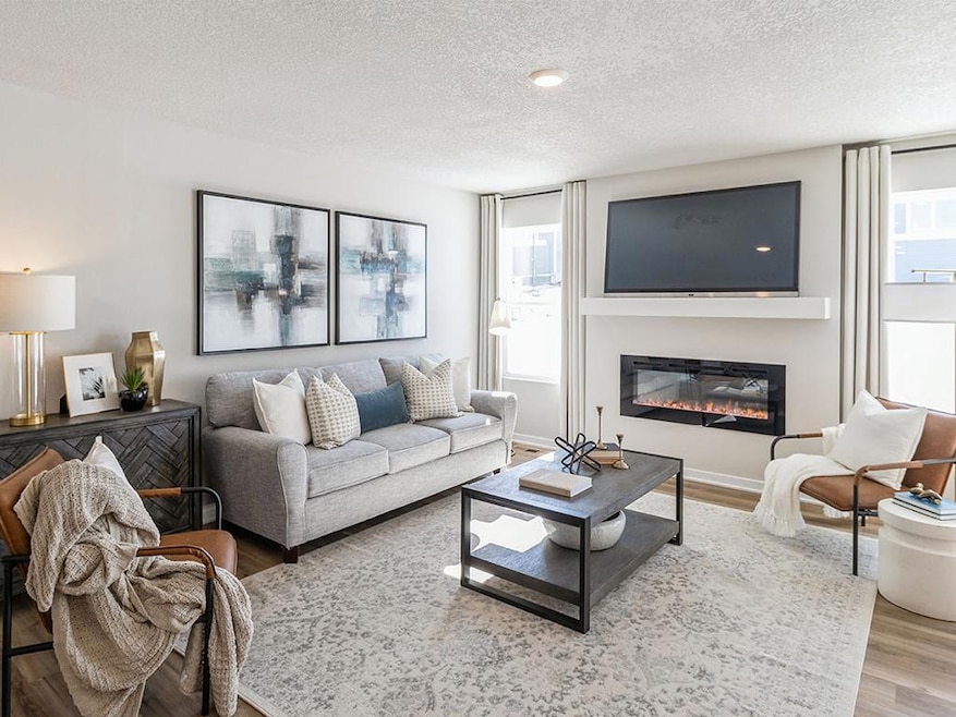 Welcome to 6288 Jennifer Ave.  Spacious Harmony floorplan living room with natural sunlight and an electric fireplace.