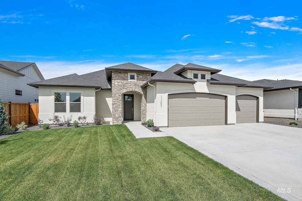 View of front of house with stucco siding, a garage, stone siding, driveway, and roof with shingles