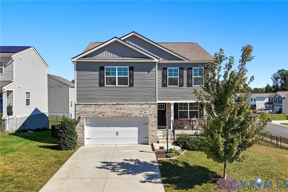 View of front of house with board and batten siding, brick siding, concrete driveway, a garage, and covered porch