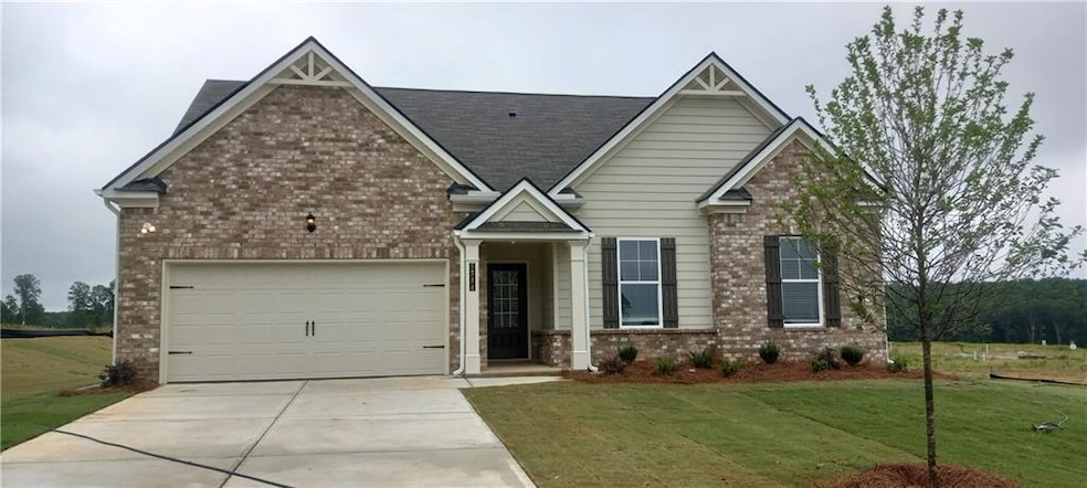 Craftsman house with brick siding, concrete driveway, a front yard, an attached garage, and a shingled roof