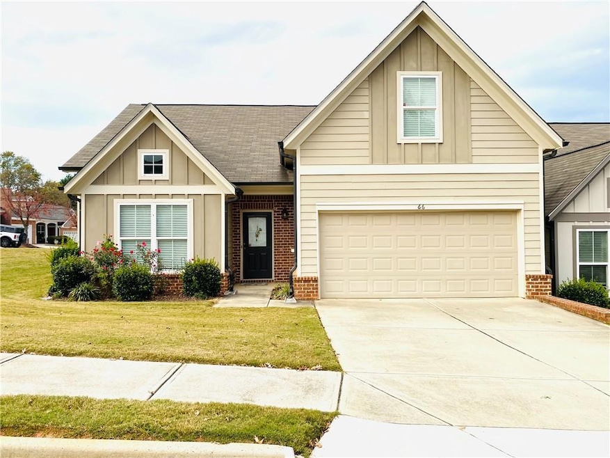 View of front of home featuring board and batten siding, brick siding, roof with shingles, and driveway