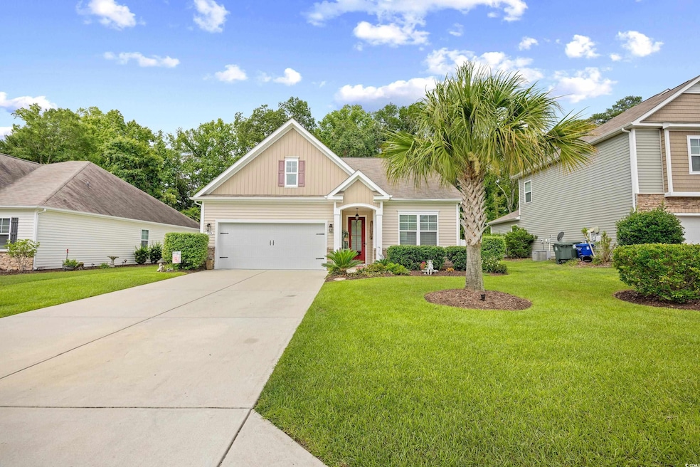 Craftsman-style house with board and batten siding, a front yard, driveway, and a garage
