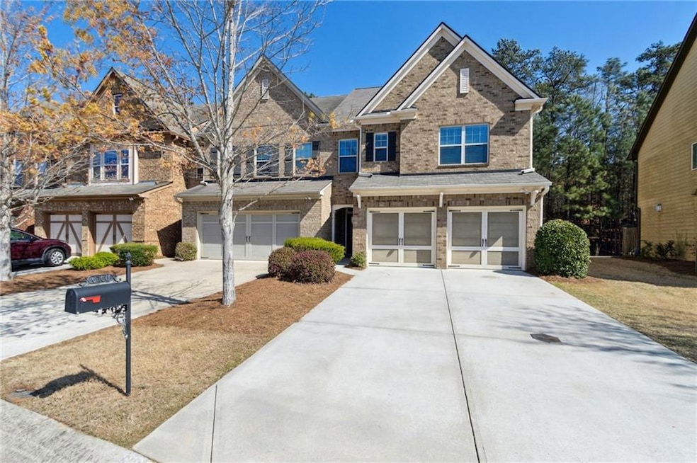 View of front of property featuring an attached garage, concrete driveway, and brick siding