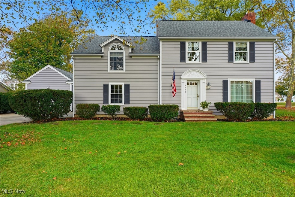 Colonial-style house with a front yard, a chimney, and roof with shingles