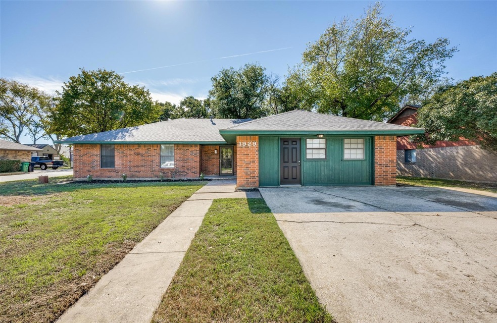 View of front of property with a front yard, brick