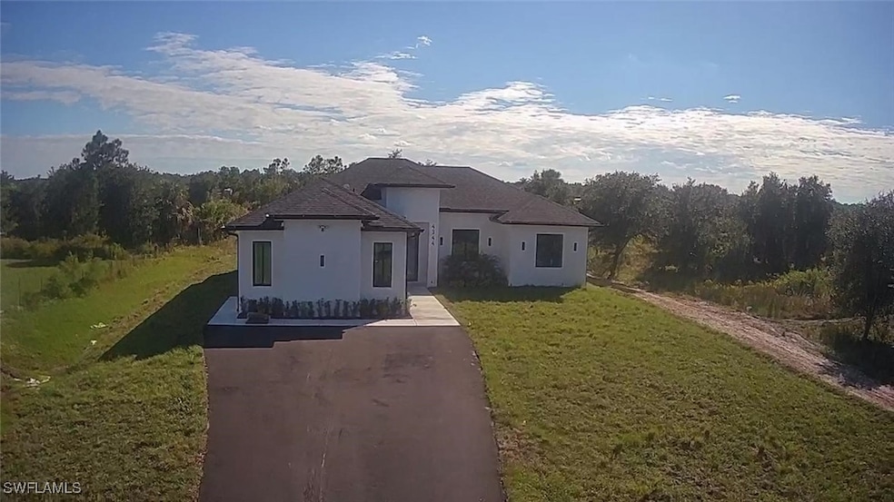 View of front of house featuring stucco siding and a front yard