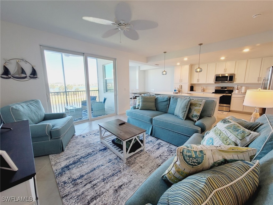 Living room featuring ceiling fan, light tile patt
