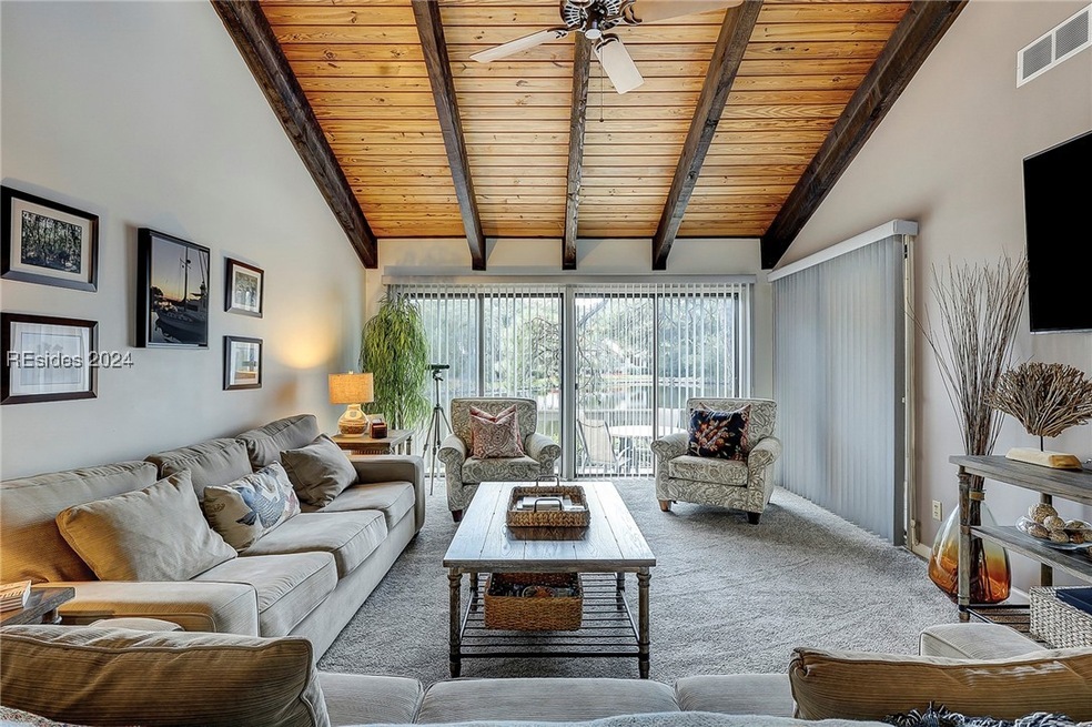 Carpeted living room featuring wood ceiling, ceili