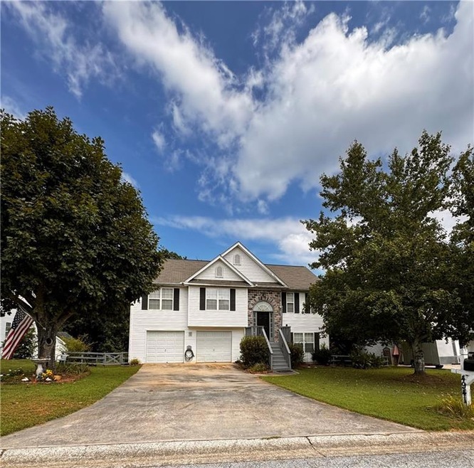 Split Level home featuring a front yard and a gara