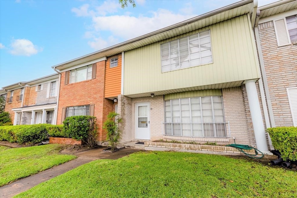 This is a two-story townhouse with a mix of brick