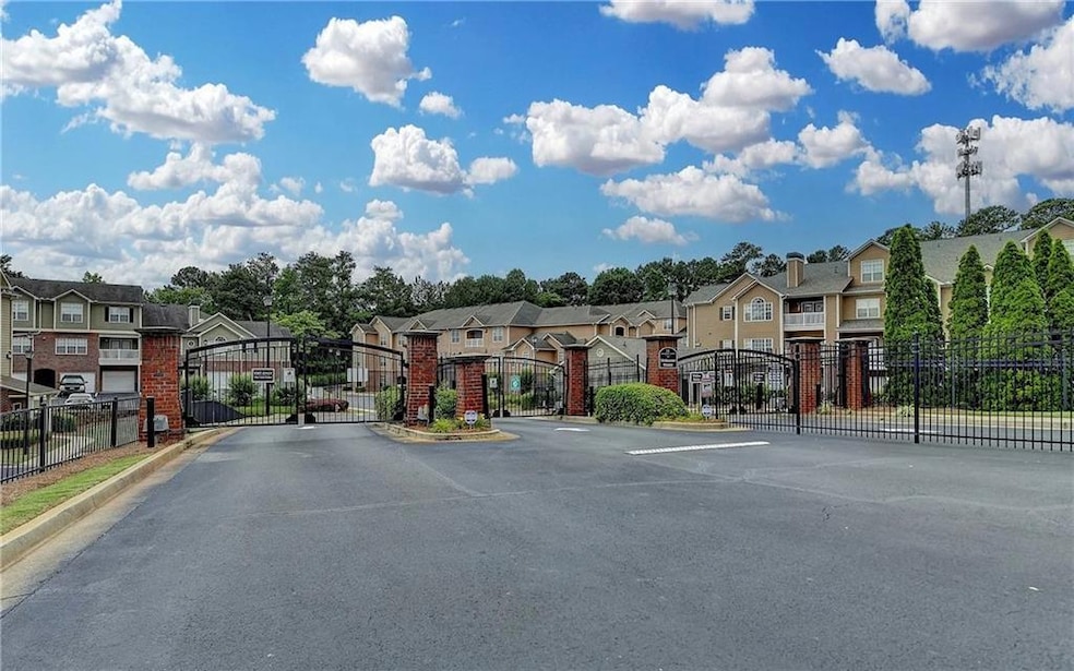 View of asphalt road with a residential view, a gate, a gated entry, and curbs