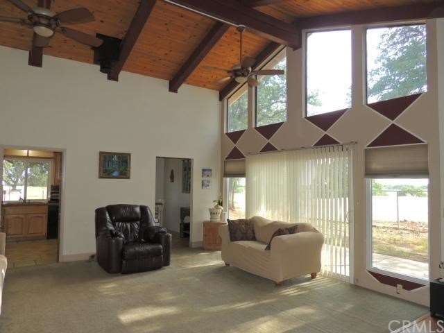 Living room with vaulted wood ceiling and wall of 