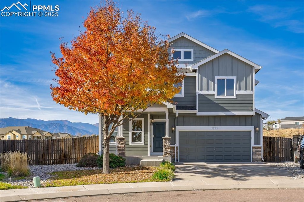 View of front of property featuring board and batten siding, stone siding, a mountain view, and concrete driveway