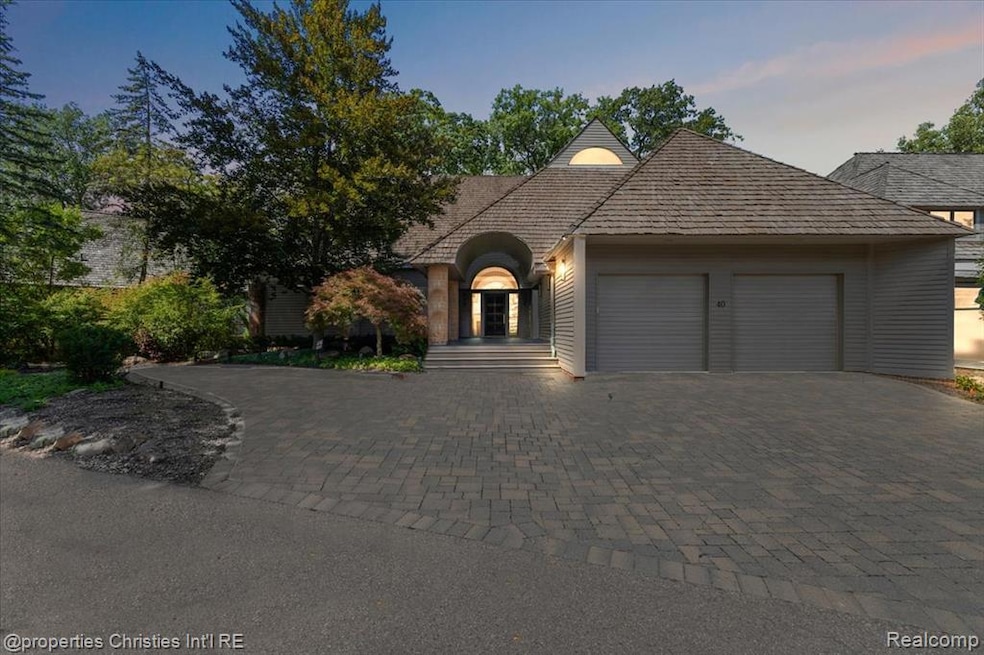 View of front facade featuring decorative driveway and a garage