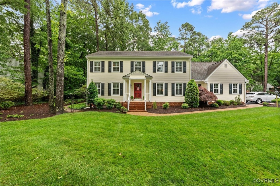 Colonial house featuring a front yard and a shingl