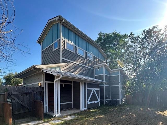 Back of house with board and batten siding and fe