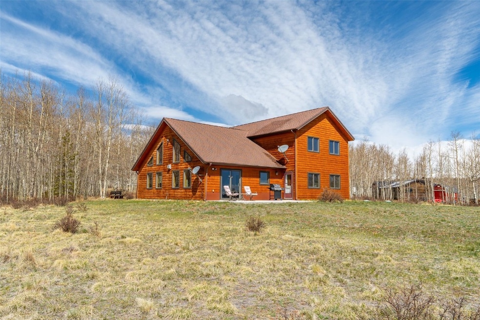 Back of house with a patio, a lawn, and a shingled