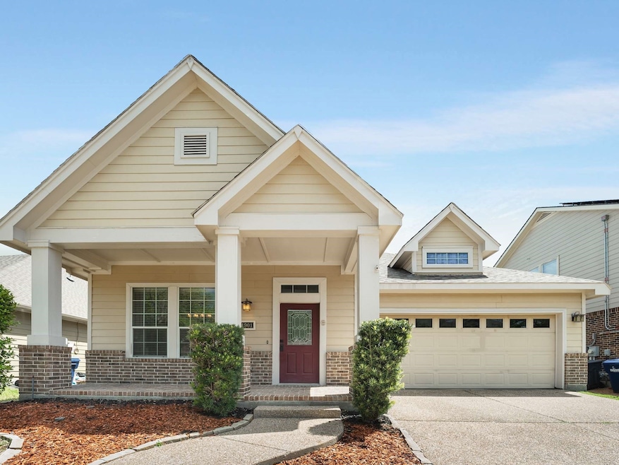 View of front of home featuring brick siding, a porch, concrete driveway, and a garage