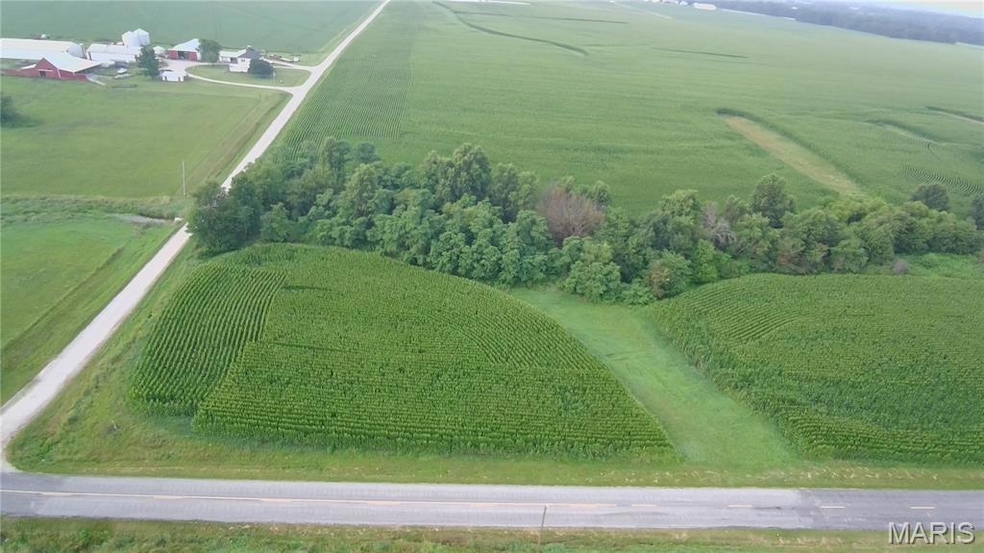 Aerial view of property and surrounding area featuring large plots for crops and rural landscape
