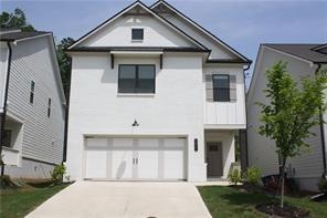View of front of property with an attached garage, driveway, and stucco siding