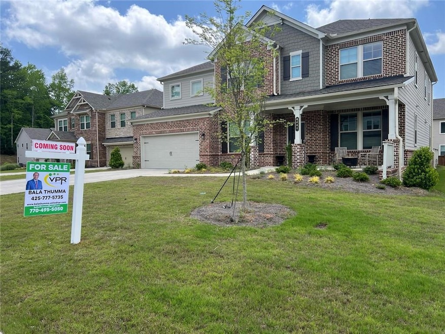Craftsman-style home with concrete driveway, a front yard, a garage, brick siding, and a porch