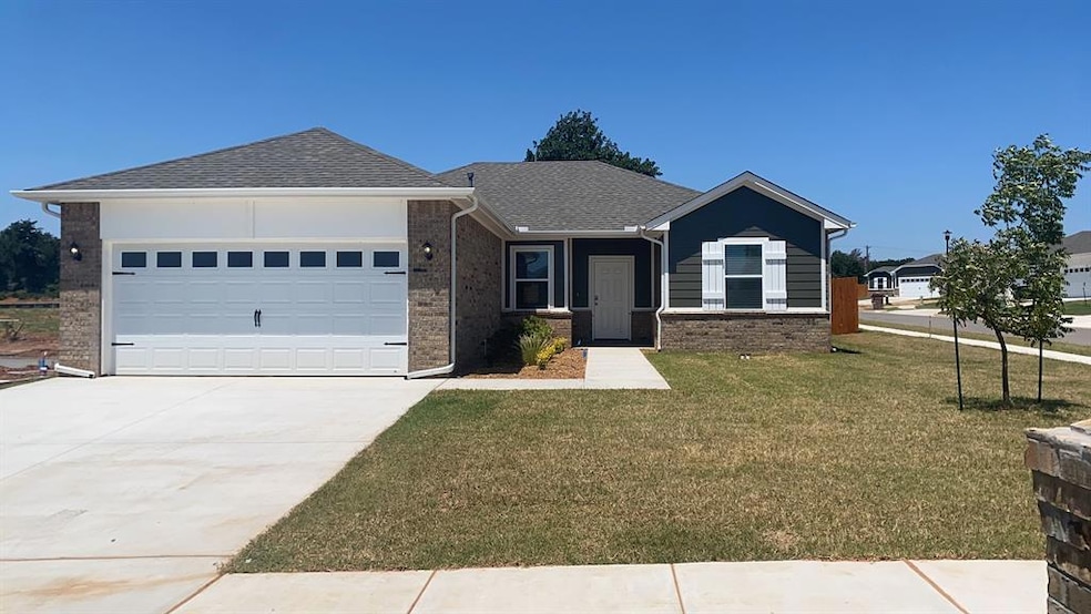 Ranch-style home with a front yard, brick siding, roof with shingles, concrete driveway, and a garage