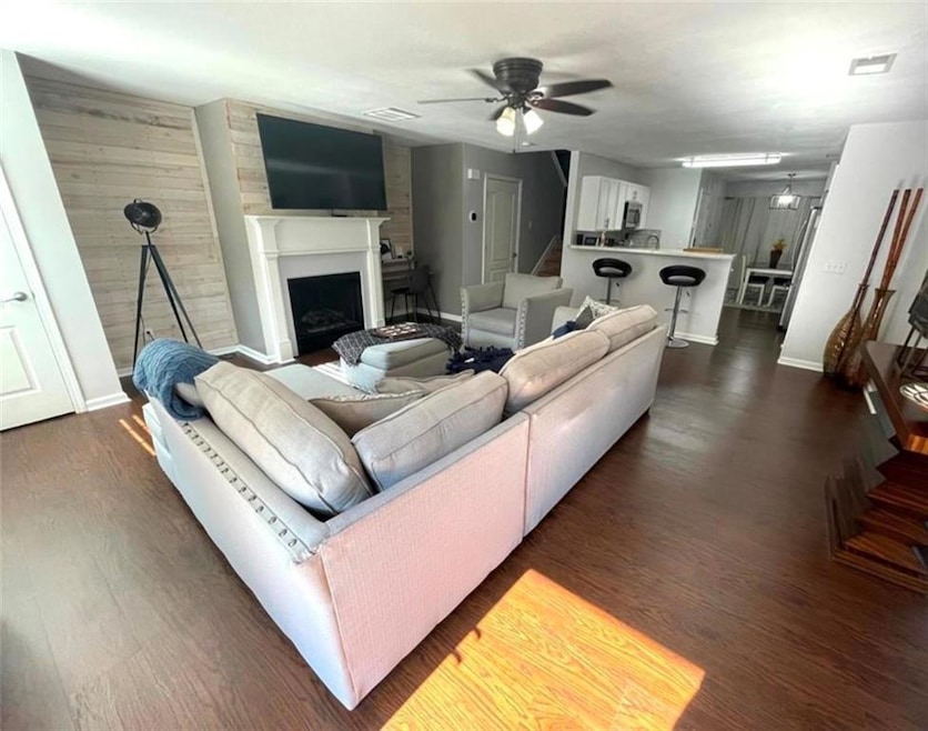 Living room featuring dark wood-style floors, a fi