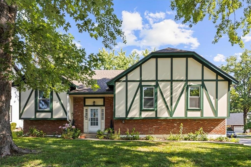 Tudor home with brick siding, a front yard, and stucco siding