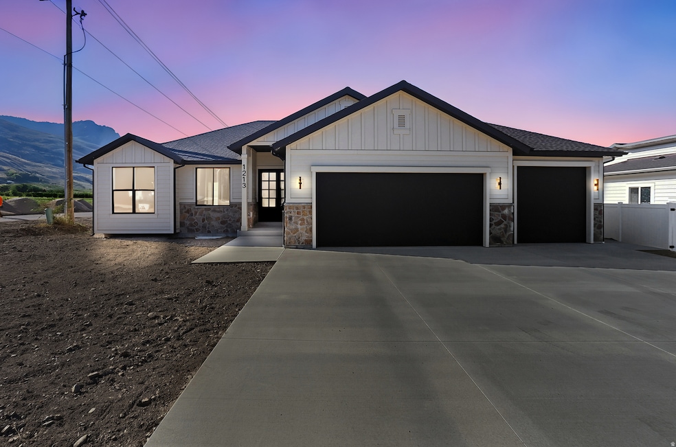Modern inspired farmhouse featuring board and batten siding, stone siding, an attached garage, a shingled roof, and driveway