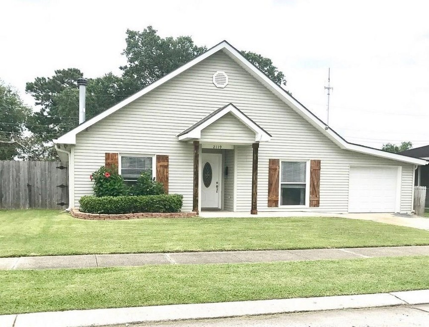 Front view of house with natural wood shutters and