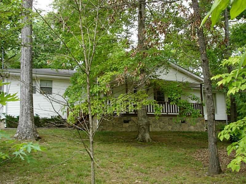 Exterior Front. Wooded lot and front porch.