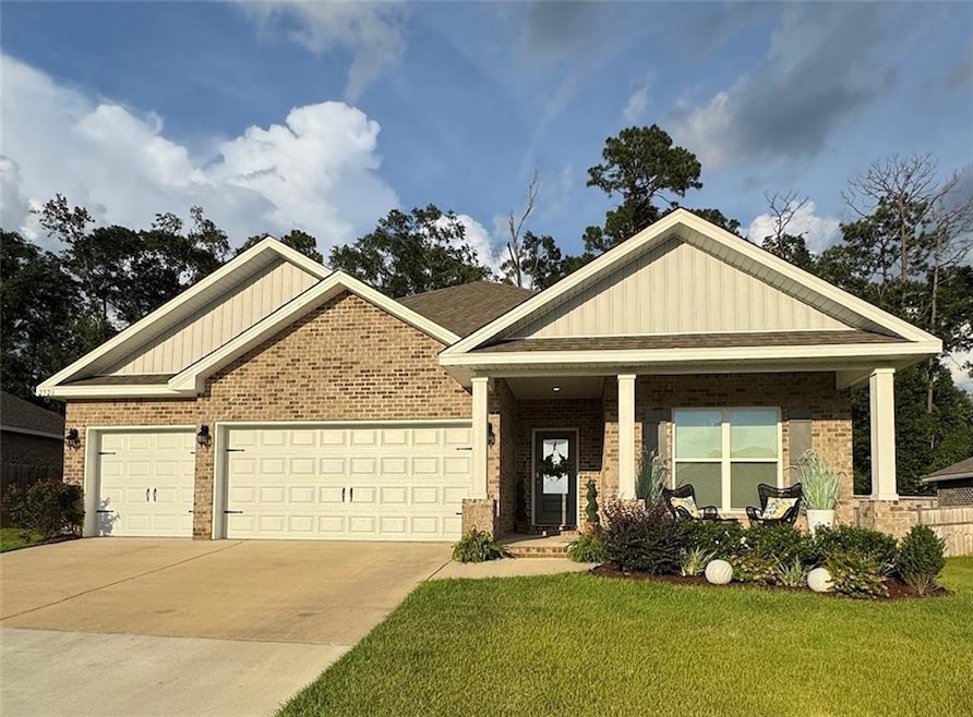 Craftsman-style home with brick siding, an attached garage, concrete driveway, and a front yard