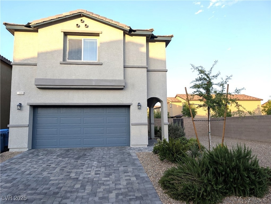View of front facade with an attached garage, stuc