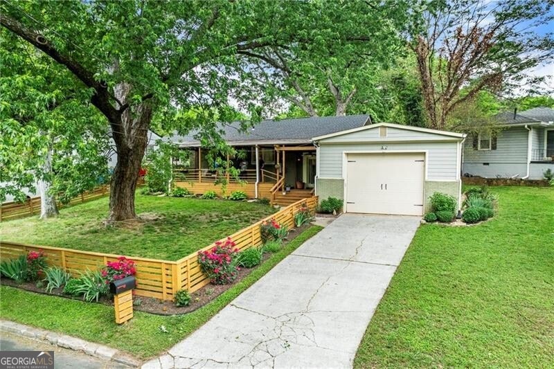 Single story home with fence, an attached garage, brick siding, a front yard, and driveway
