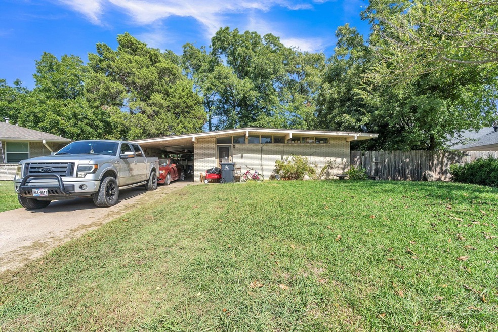 View of front of house with a front lawn and a car