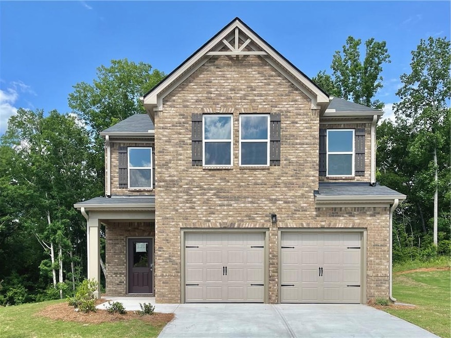 Craftsman-style home featuring a garage, concrete driveway, brick siding, and a front yard