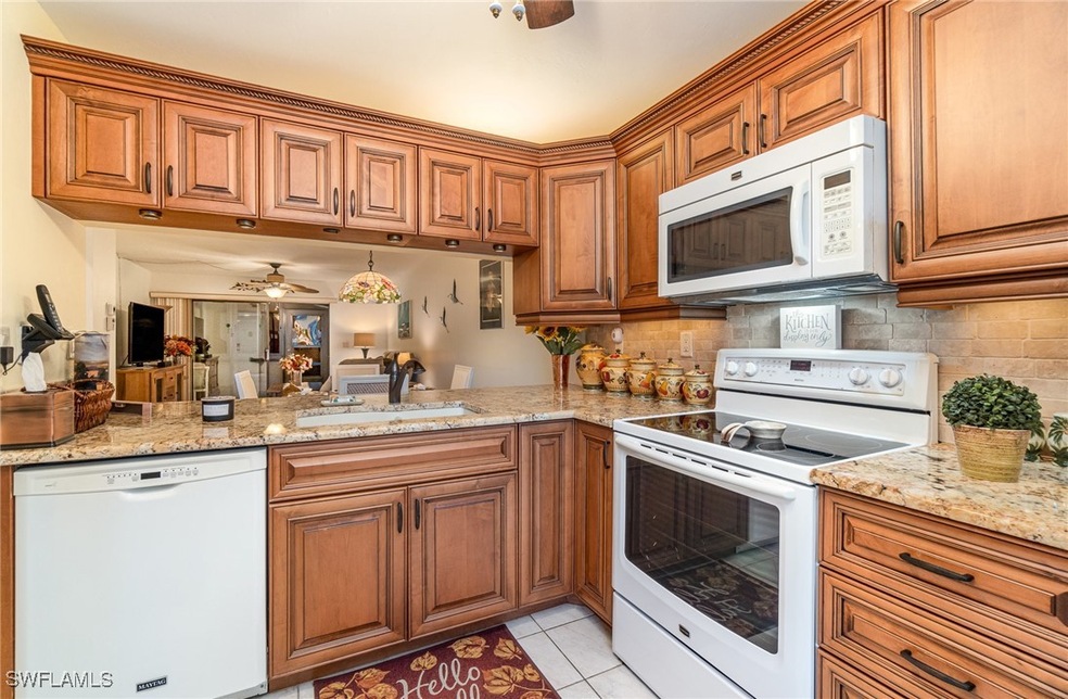 Kitchen with white appliances, backsplash, sink, c