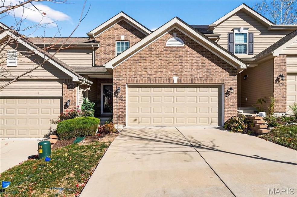 Traditional-style house with concrete driveway, brick siding, and a garage